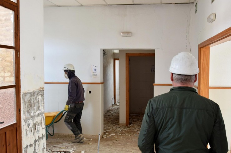 Comienzan las obras de rehabilitación de las Escuelas Graduadas 17/03/2023 Ginés Campillo, teniente alcalde, ha visitado el centenario edificio de la Plaza del Salitre en el inicio de los trabajos que le devolverán el esplendor como espacio polivalente   Las obras de rehabilitación de las Escuelas Graduadas, icónico edificio de la barriada del Salitre, son ya una realidad. La Concejalía de Patrimonio Histórico del Ayuntamiento de Mazarrón, que dirige el teniente alcalde Ginés Campillo, ha iniciado esta semana los trabajos para recuperar el inmueble erigido a principios de 1900. Junto a Francisco Javier López, gerente de la constructora MUSAN —empresa adjudicataria de las obras—, el edil ha recorrido el centenario edificio en el arranque de su recuperación como espacio polivalente. La edificación venía languideciendo hasta su cierre, en agosto de 2020, ante la aparición de diversas grietas por hundimientos provocados por los diferentes asientos en el terreno. Ahora, el proyecto de rehabilitación se desarrollará buscando la creación de espacios versátiles para poder albergar diferentes actividades programadas por el consistorio o colectivos. De este modo, se pondrá en valor la edificación existente al eliminar los volúmenes exteriores anexos, dándole un carácter abierto y público al que ha sido, hasta ahora, su patio exterior. No obstante, dado que se trata de un edificio con más de un siglo de antigüedad se conservará tanto la fachada principal como el patio interior del edificio con su singular palmera. Además, sobre su única planta se contemplan los siguientes espacios: entrada a modo vestíbulo con escalera y rampa que conecten el nivel de la calle con el interior de la edificación, recepción, office, salón de actos, ocho salas polivalentes, cuatro aseos adaptados, patio interior, cuarto de instalaciones, dos zonas de almacenaje, y cuarto de basuras. Las obras tienen un plazo de ejecución de un año. 100 años al servicio de los vecinos Las Escuelas Graduadas comenzaron a construirse en 1911, siendo el segundo centro de enseñanza que dividía a los alumnos por edad y nivel en la provincia de Murcia. Una construcción fruto de la modernidad de su época por la amplitud de sus espacios, ventilación, iluminación y aislamiento exterior.. El Proyecto de Edificación original data del año 1910 y se trata de un excepcional documento en el que aparecen la planta, alzado y sección originalmente previstas para el edificio. El Arquitecto que figura es D. Luis Domingo de Rute, referente de la arquitectura escolar en todo el ámbito español durante los primeros compases del S.XX. Sus instalaciones han prestado servicio a los mazarroneros desde entonces. Colegio, Escuela de Adultos y hasta como ambulatorio médico.  Actualmente, albergaba actualmente las sedes de la Asociación Musical Maestro Eugenio Calderón, la Escuela de Adultos y otras cuatro entidades sociales y ciudadanas, entre ellas, la junta local de lucha contra el cáncer y la de comerciantes del municipio.